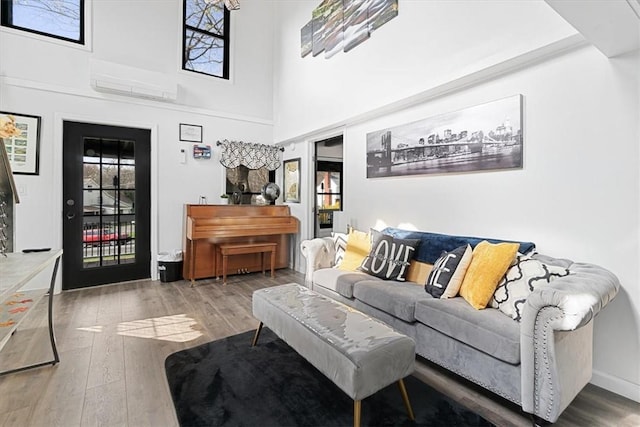 living room with a towering ceiling and wood-type flooring