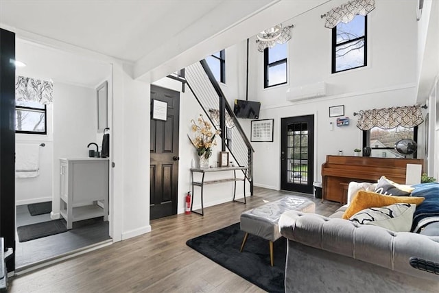 living room featuring a chandelier, wood-type flooring, and an AC wall unit