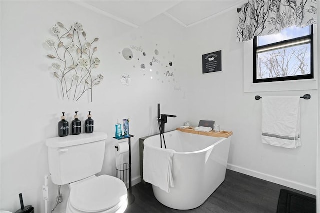 bathroom featuring hardwood / wood-style floors, a washtub, and toilet