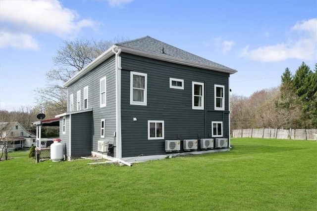 back of house featuring ac unit and a lawn