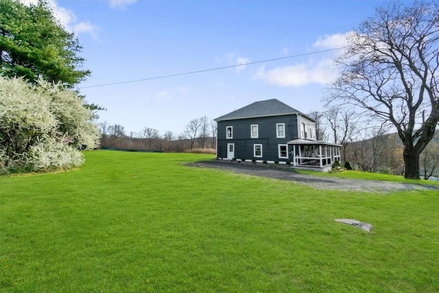 back of house featuring a lawn and a sunroom