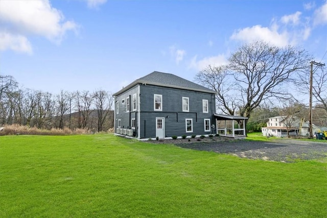 rear view of property featuring a lawn