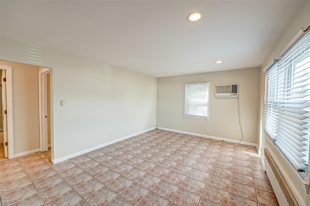 spare room with an AC wall unit, a baseboard radiator, and light tile patterned floors