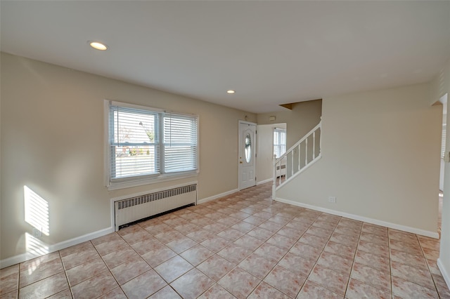 entryway with radiator and light tile patterned floors