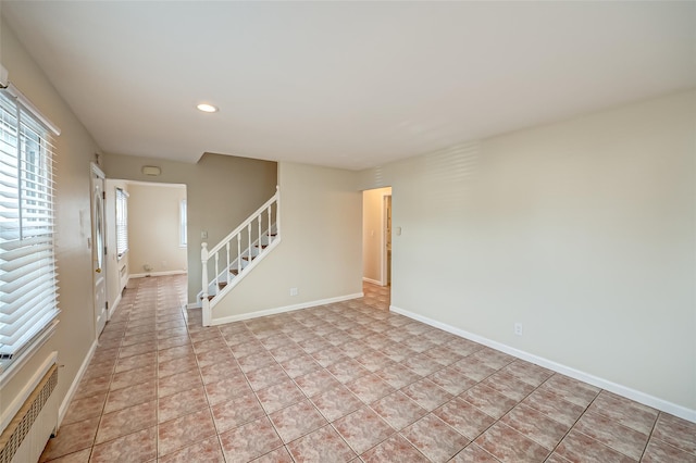 tiled empty room featuring radiator heating unit