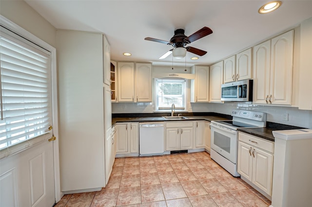 kitchen featuring ceiling fan, sink, light tile patterned floors, white appliances, and decorative backsplash