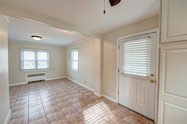 foyer with ceiling fan, light tile patterned floors, radiator, and crown molding