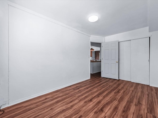 unfurnished bedroom featuring a closet and dark hardwood / wood-style flooring