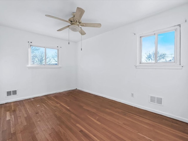 spare room with wood-type flooring, ceiling fan, and a healthy amount of sunlight