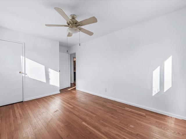 empty room with ceiling fan and hardwood / wood-style flooring