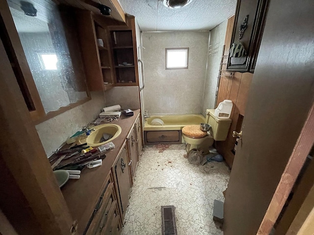 bathroom with toilet, a textured ceiling, and vanity