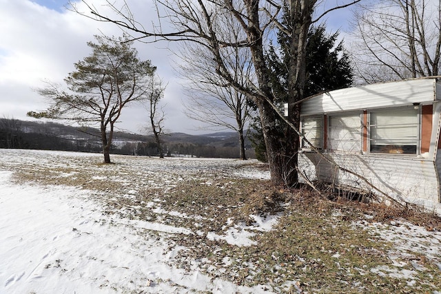 yard covered in snow with a mountain view