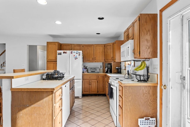 kitchen with white appliances, light tile patterned floors, and a kitchen breakfast bar