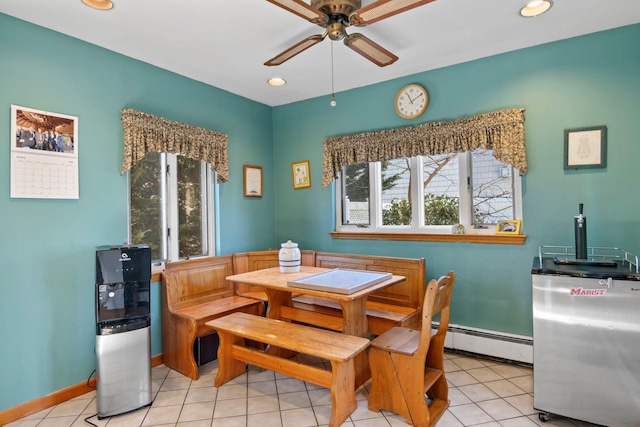 tiled dining space featuring ceiling fan and a baseboard radiator