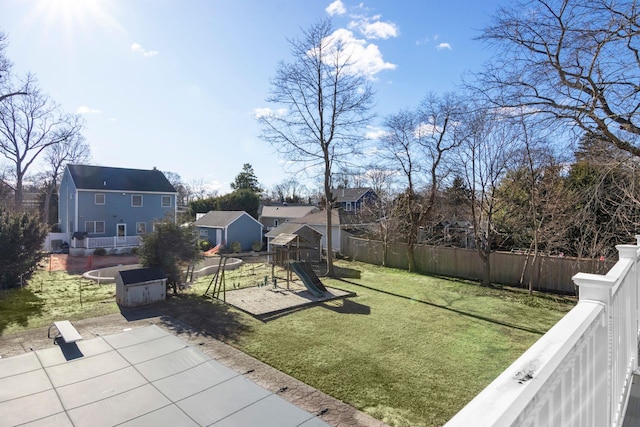 view of yard featuring a trampoline, a playground, and a patio area