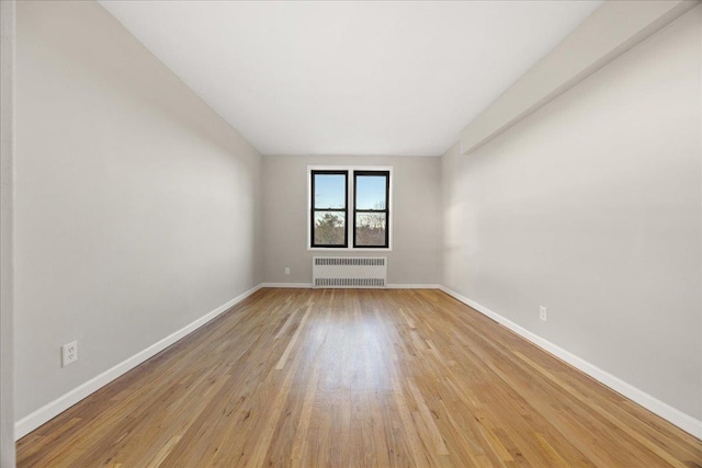 empty room featuring radiator and light wood-type flooring