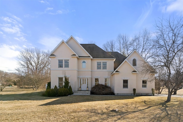 view of front of house with stucco siding and a front lawn