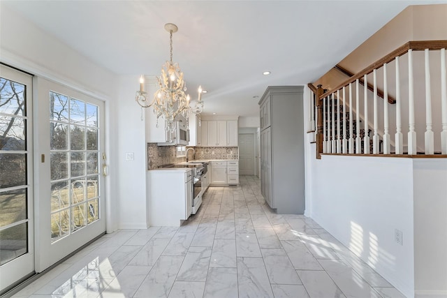 kitchen featuring decorative light fixtures, decorative backsplash, recessed lighting, marble finish floor, and a sink