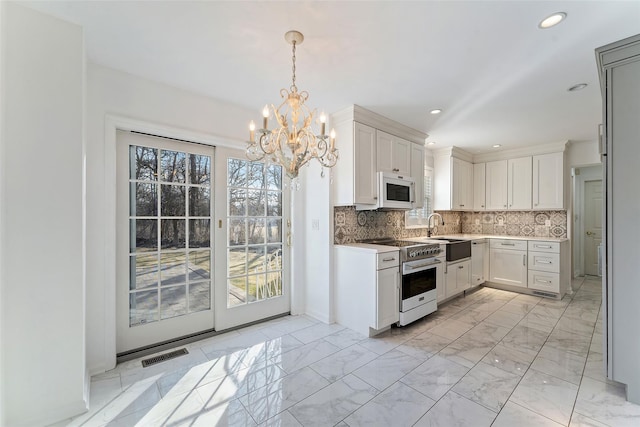 kitchen with white microwave, visible vents, high end stove, decorative backsplash, and marble finish floor