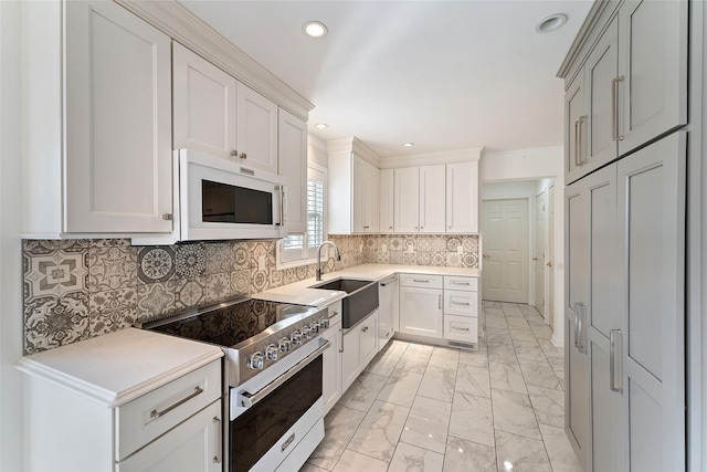 kitchen with marble finish floor, a sink, electric range oven, light countertops, and white microwave