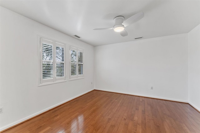 unfurnished room featuring visible vents, baseboards, a ceiling fan, and wood-type flooring