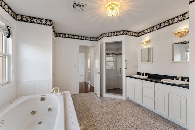 bathroom with a sink, visible vents, a jetted tub, and a stall shower