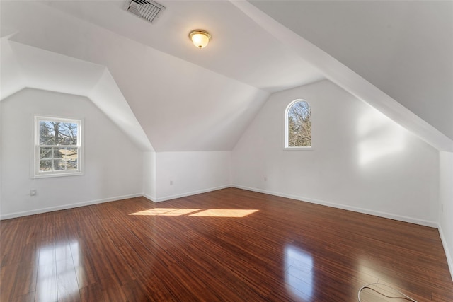 bonus room with visible vents, baseboards, vaulted ceiling, and hardwood / wood-style flooring