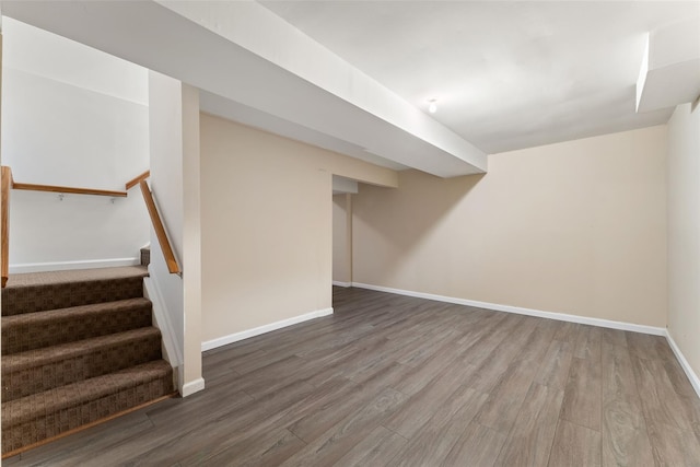 finished basement featuring stairs, baseboards, and wood finished floors