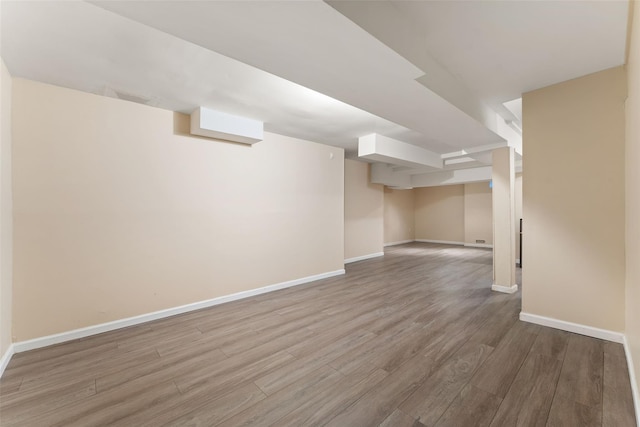 finished basement featuring wood finished floors and baseboards