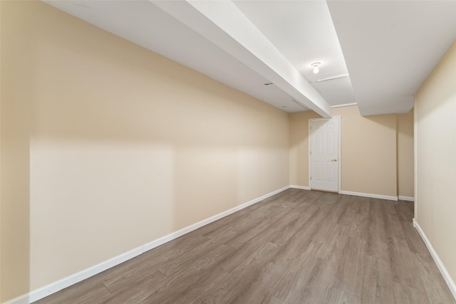 finished below grade area featuring wood finished floors and baseboards