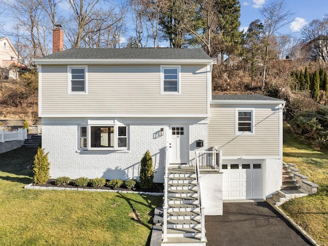 front facade with a front yard and a garage