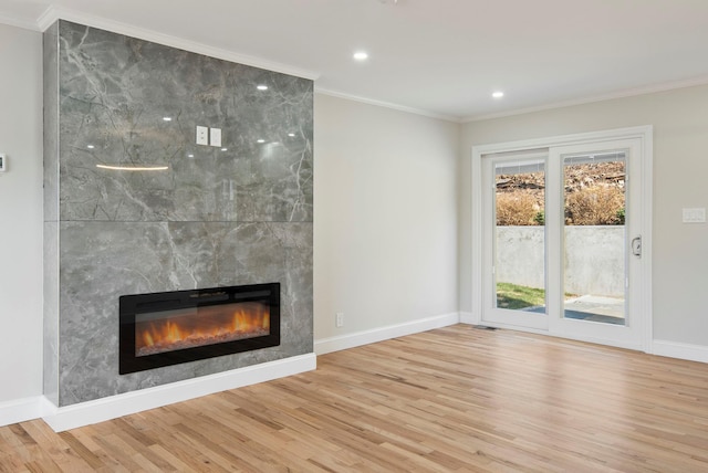 unfurnished living room with a healthy amount of sunlight, a tiled fireplace, and light hardwood / wood-style floors