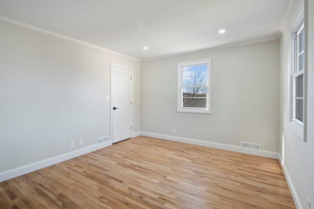 empty room featuring crown molding and light hardwood / wood-style flooring