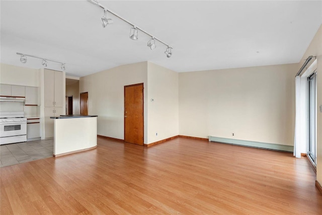 unfurnished living room with baseboard heating and light wood-type flooring