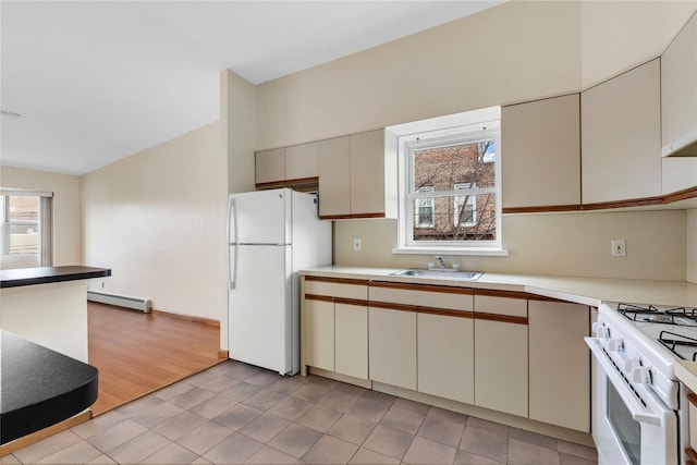 kitchen with white appliances, a baseboard radiator, and sink