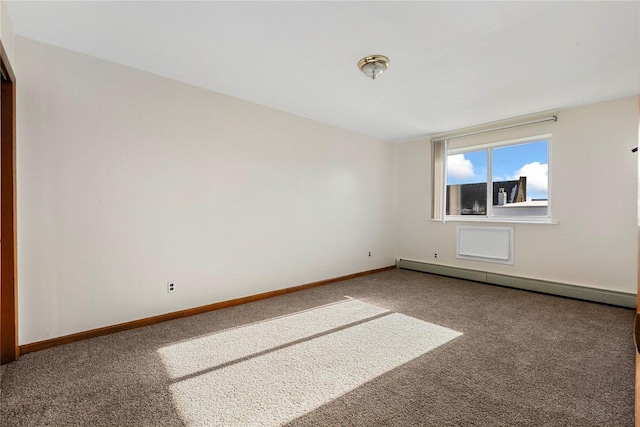 empty room featuring carpet flooring and a baseboard heating unit