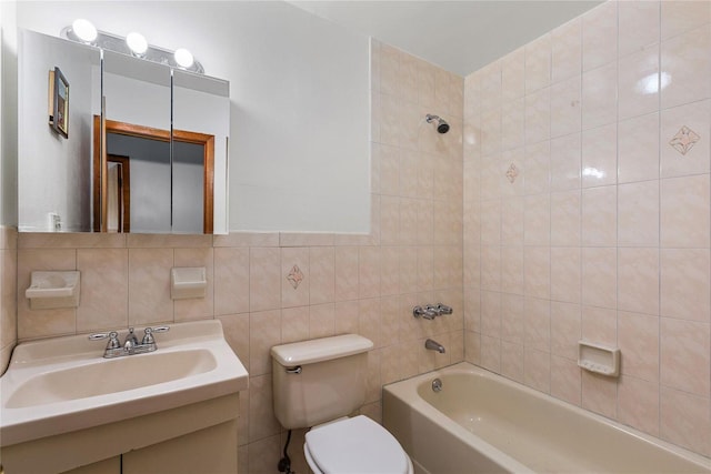 full bathroom featuring tiled shower / bath combo, tasteful backsplash, toilet, vanity, and tile walls