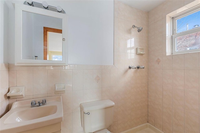 bathroom with sink, toilet, tile walls, and tiled shower