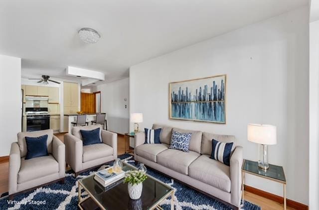 living room featuring ceiling fan and hardwood / wood-style floors