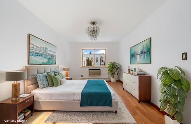 bedroom with a notable chandelier and light hardwood / wood-style flooring