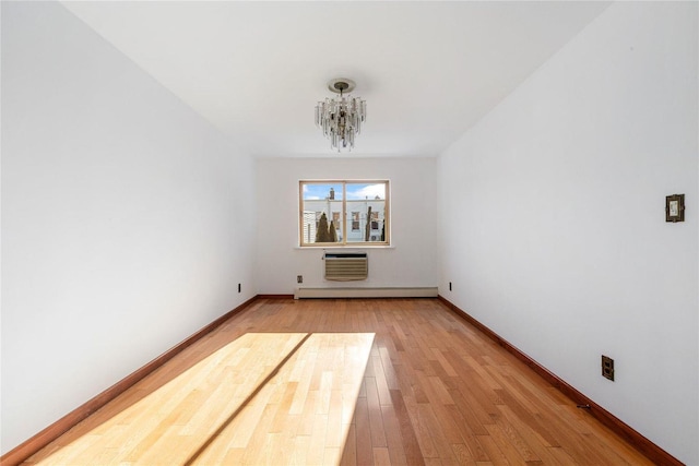 unfurnished living room with a baseboard heating unit, hardwood / wood-style flooring, an AC wall unit, and a notable chandelier