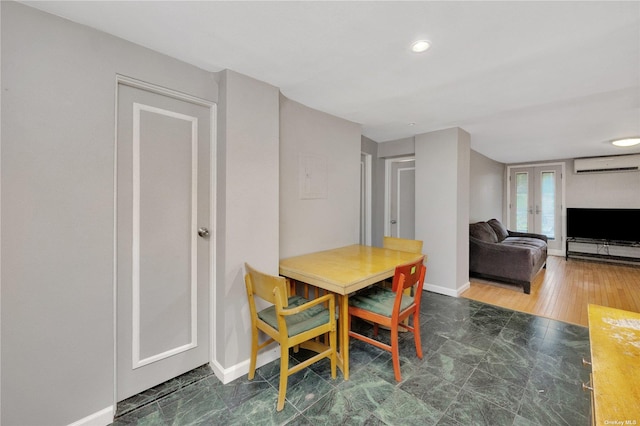 dining area featuring an AC wall unit and french doors