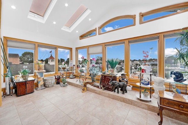 sunroom / solarium featuring vaulted ceiling with skylight and a water view