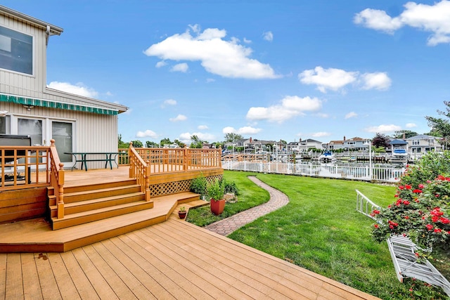 wooden deck with a yard and a water view