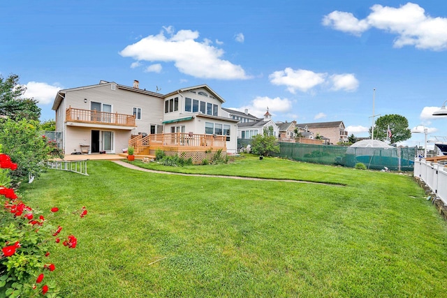 rear view of house featuring a lawn and a wooden deck