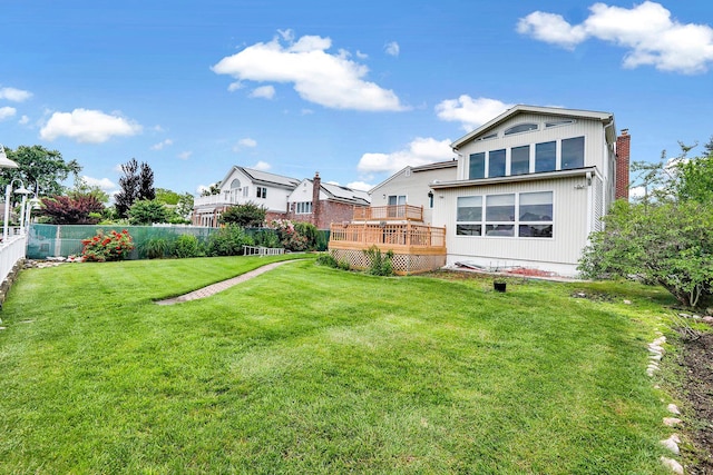 rear view of property featuring a lawn and a deck