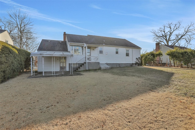 rear view of house featuring a lawn