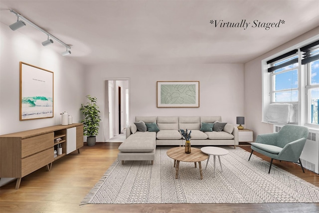 living room with radiator, rail lighting, and light hardwood / wood-style floors