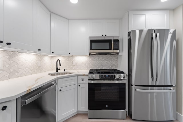 kitchen with white cabinetry, sink, decorative backsplash, and appliances with stainless steel finishes