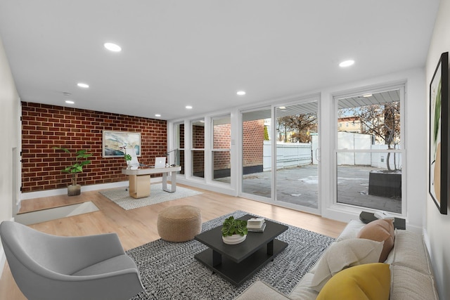 living room with brick wall and hardwood / wood-style floors